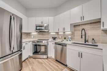 Modern kitchen with white cabinets and stainless appliances